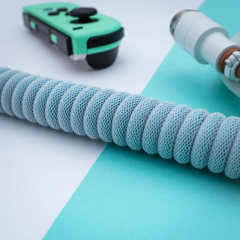 Aqua coiled cable angled aviator connector Custom PBT Islander Keyboard Cable features a sleek, light blue braided coil, a detachable USB-C connector, and high-quality CNC metal housing for durability.