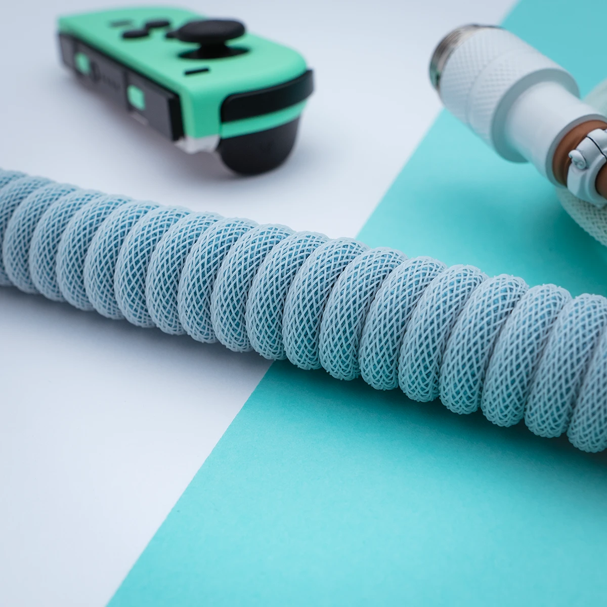 Aqua Spiralkabel abgewinkelter Pilotenstecker Das benutzerdefinierte PBT Islander-Tastaturkabel verfügt über eine schlanke, hellblaue geflochtene Spule, einen abnehmbaren USB-C-Anschluss und ein hochwertiges CNC-Metallgehäuse für Langlebigkeit.