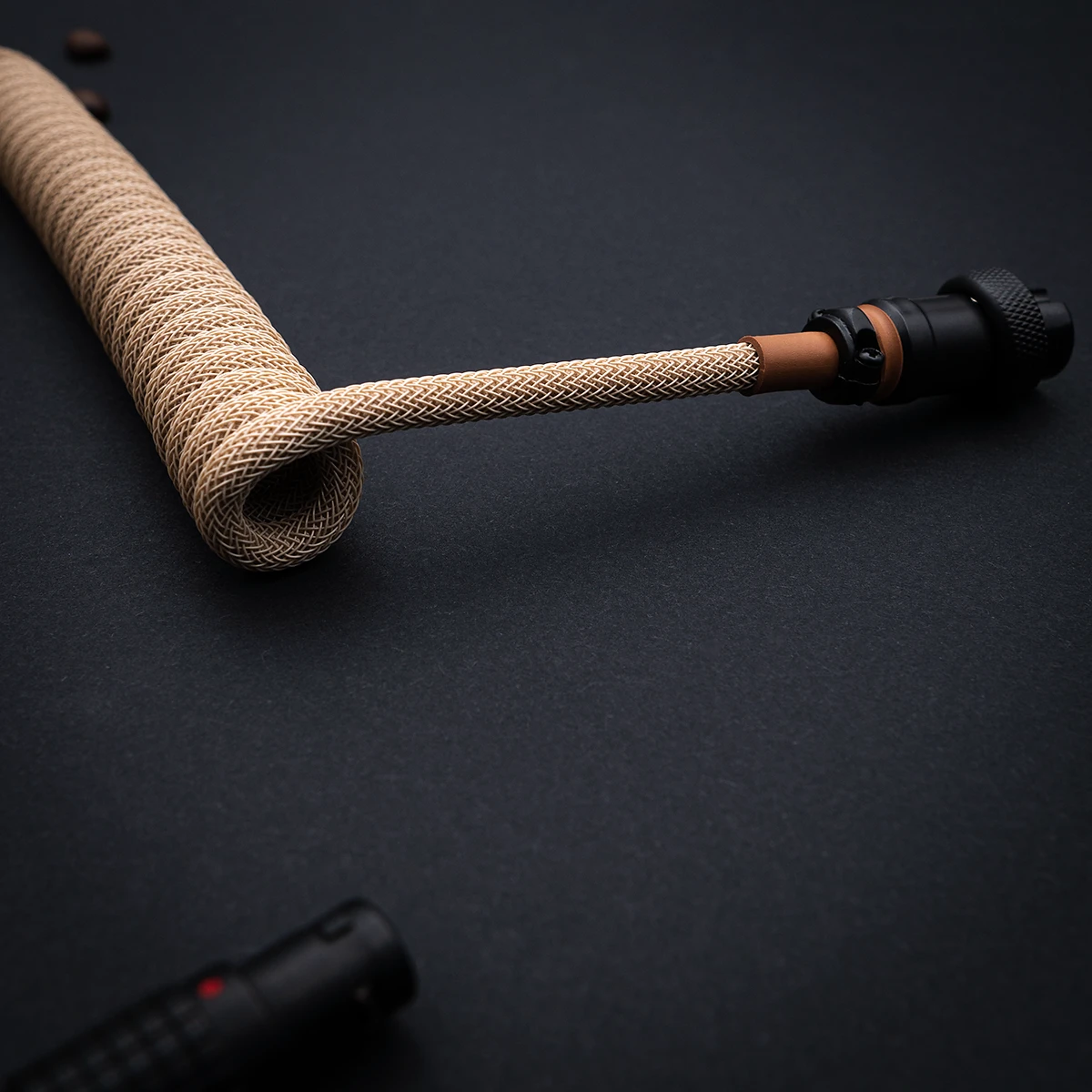 Beige Spiralkabel abgewinkelter Pilotenstecker Das aufgewickelte Paracord-Tastaturkabel verfügt über ein schlankes Geflecht in Beige mit einem abnehmbaren Pilotenstecker für Vielseitigkeit und hochwertige Verarbeitung.