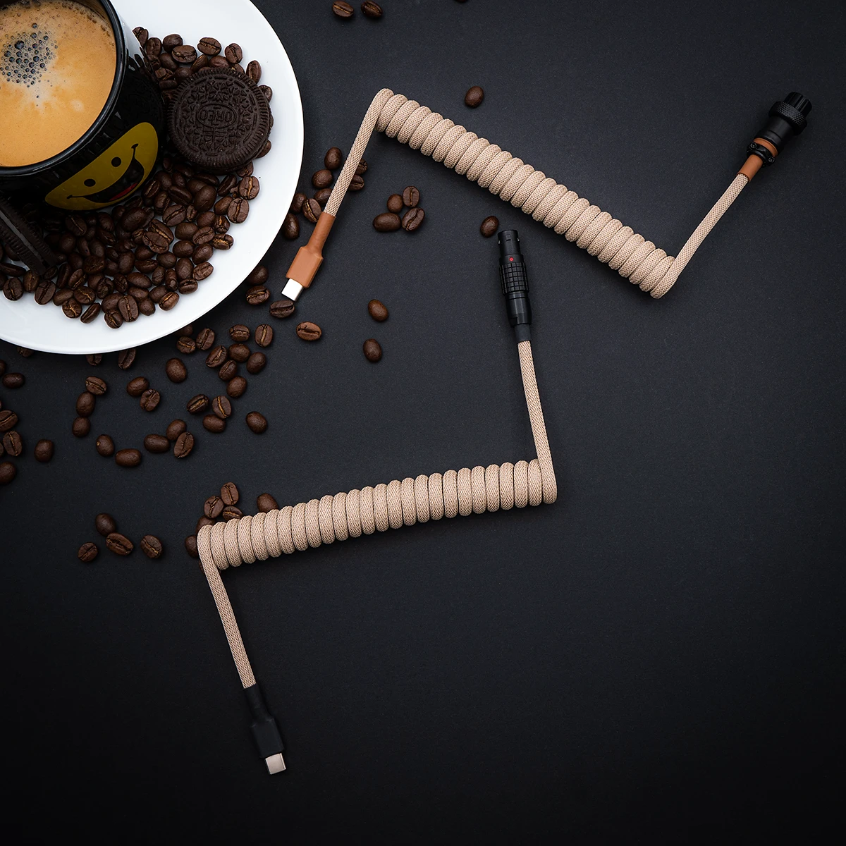 Beige Spiralkabel über Kopf USB C Kaffee Aufgewickeltes beiges Paracord-Tastaturkabel mit USB-C- und Pilotensteckern, mit hochwertigem Geflecht und einem schlanken Finish inmitten von Kaffeebohnen.