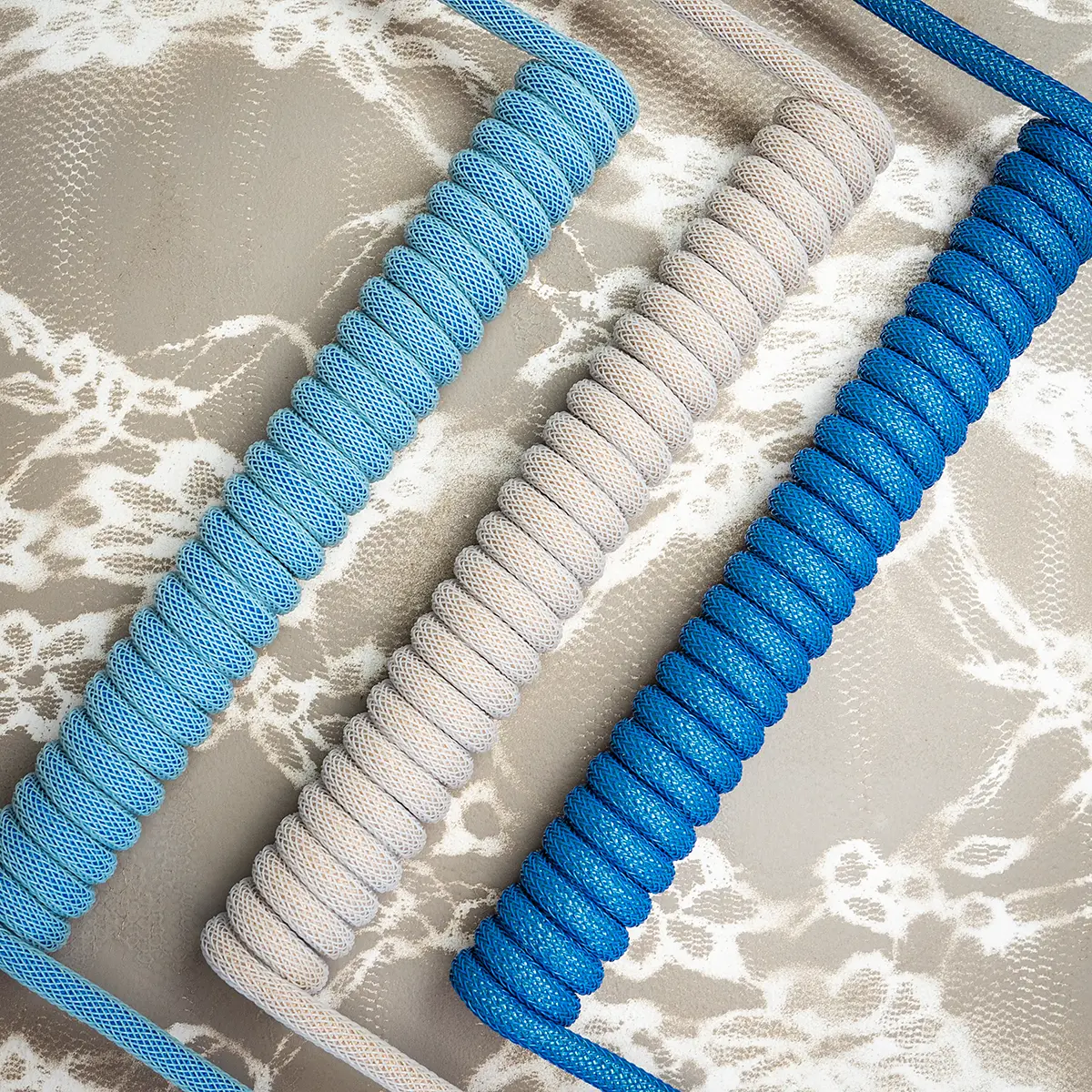 Blue beige coiled cables overhead lace Custom keyboard cables showcased in blue and gray braiding, featuring a prominent coil design, high-quality finish, and detachable connectors.