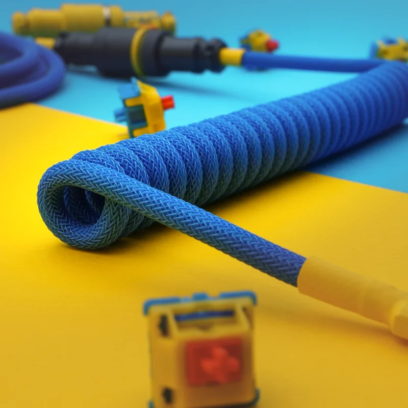Blue coiled cable angled usb c detail Coiled blue paracord keyboard cable with detachable USB-C and micro-USB connectors, showcasing excellent braiding and heatshrink finishes.