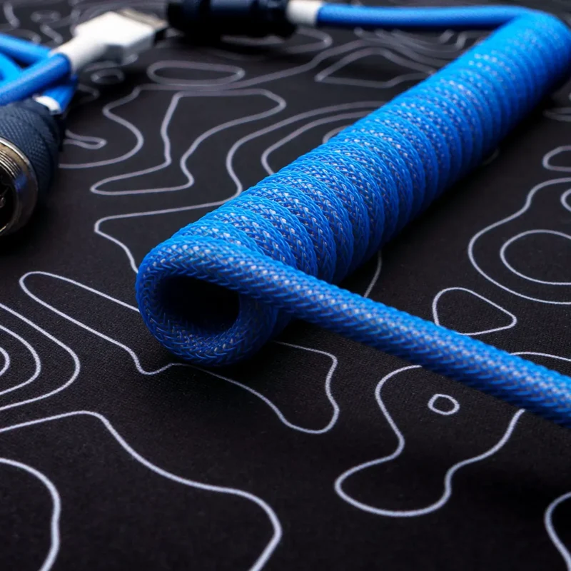 Blue coiled cable closeup topographic pattern Coiled blue paracord keyboard cable with braided texture, featuring detachable connectors and high-quality CNC metal housing for durability.