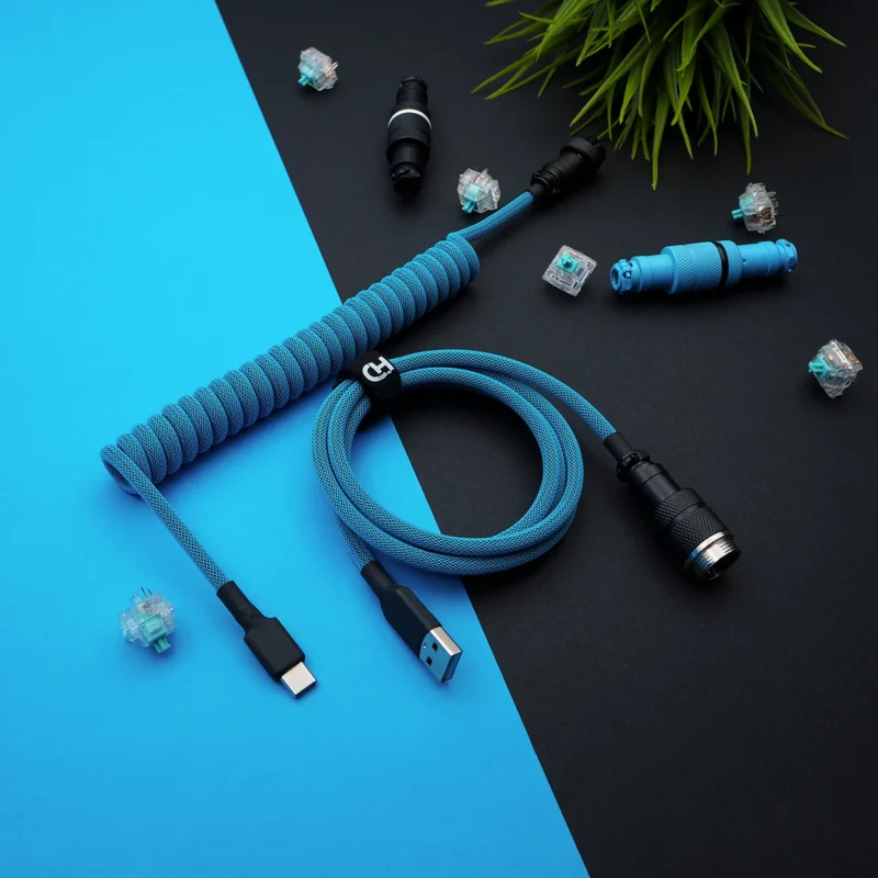 Blaues Spiralkabel usb c gx16 Draufsicht Aufgewickeltes blaues Paracord-Tastaturkabel mit USB-C- und GX16-Anschlüssen. Die hochwertige Verarbeitung, die abnehmbaren Stecker und das strukturierte Geflecht erhöhen die Haltbarkeit.