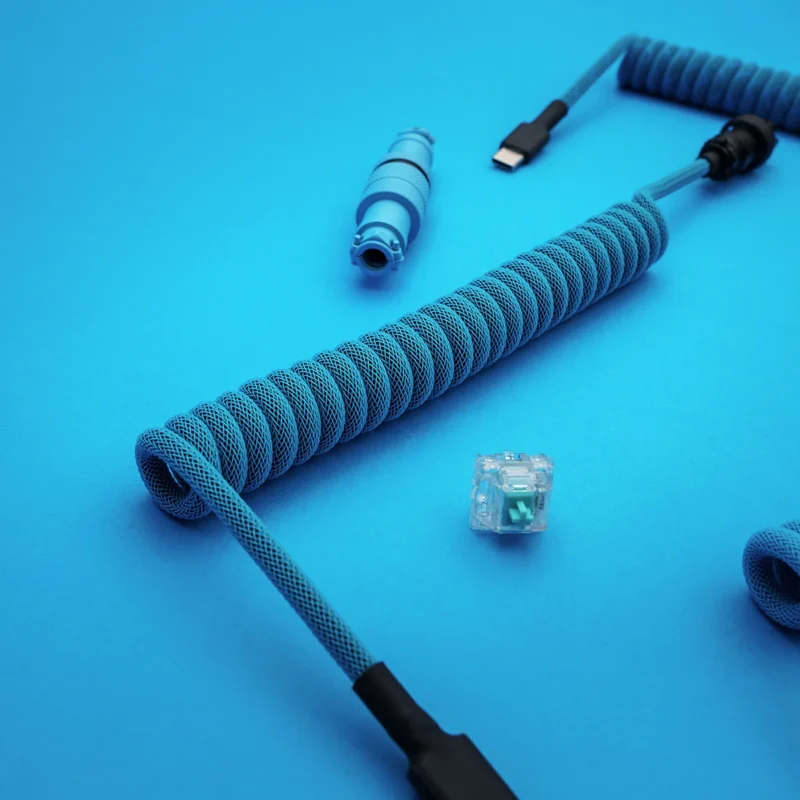 Blaues Spiralkabel USB C Draufsicht Flieger Ein leuchtend blaues Paracord-Tastaturkabel verfügt über ein spiralförmiges Design, einen abnehmbaren USB-C-Anschluss und ein CNC-Metallgehäuse für Qualität und Langlebigkeit.