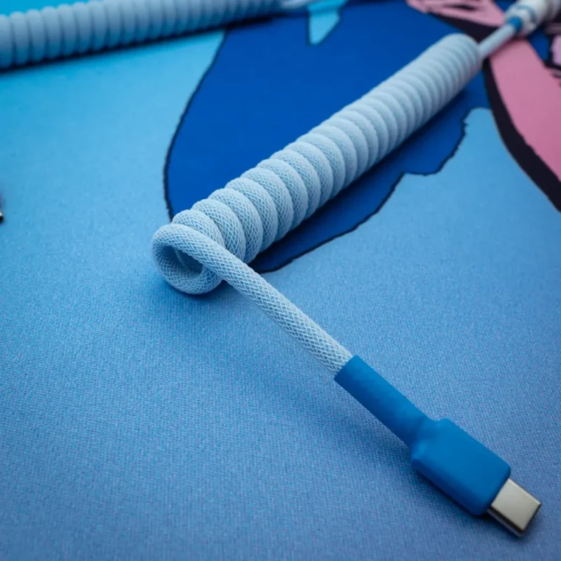 Câble USB-C bleu spiralé, vue en angle Câble de clavier bleu spiralé avec connecteur USB-C, doté d'un design texturé en paracorde et d'une finition de haute qualité, idéal pour les configurations personnalisées.