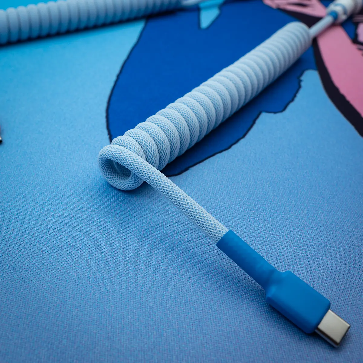 Blaues gewickeltes USB-C-Kabel mit abgewinkelter Ansicht Aufgewickeltes blaues Tastaturkabel mit USB-C-Stecker, strukturiertem Paracord-Design und hochwertiger Verarbeitung, perfekt für benutzerdefinierte Setups.