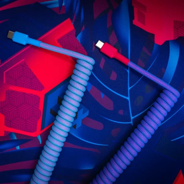 Blue pink usb c coiled cable overhead view Vibrant GMK Vaporwave keyboard cable featuring a coiled design with blue and pink hues, USB-C connectors, and durable braided paracord for flexibility.