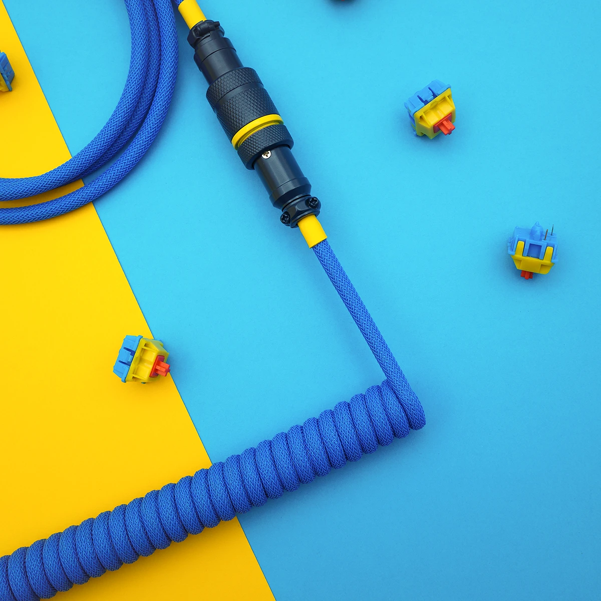 Blue yellow coiled cable aviator overhead Coiled blue keyboard cable featuring a detachable aviator connector, durable paracord, and clean braiding. Ideal for custom setups.