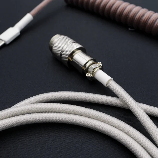 Custom brown Eevee keyboard cable featuring a sturdy CNC metal aviator connector, textured braided paracord, and cooling coil design for flexibility.