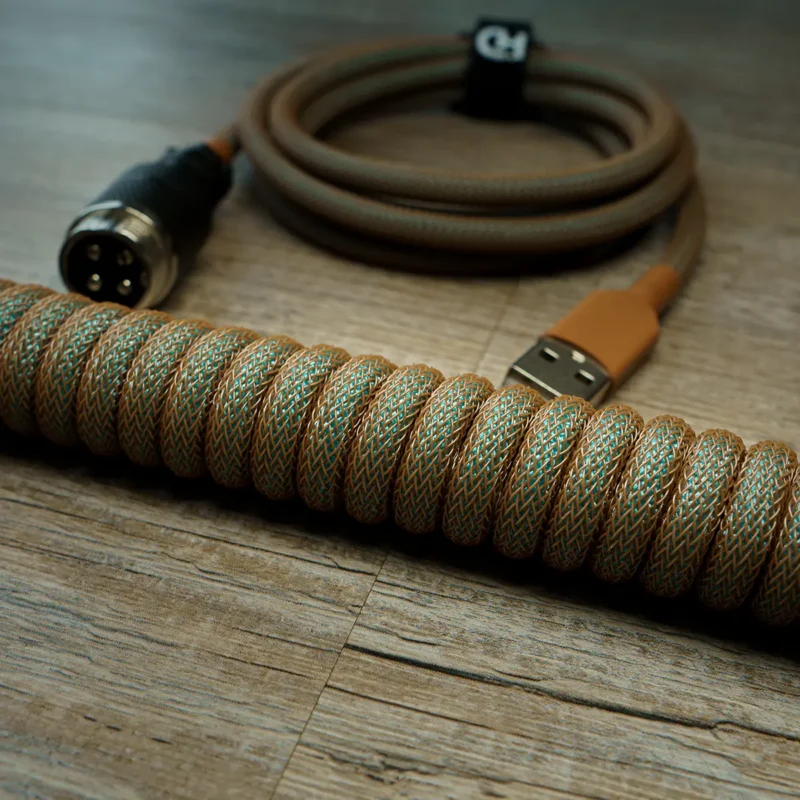 Câble de clavier GMK Copper coiled avec un techflex marron et un paracord vert, doté d'un connecteur USB A et d'un GX16 noir
