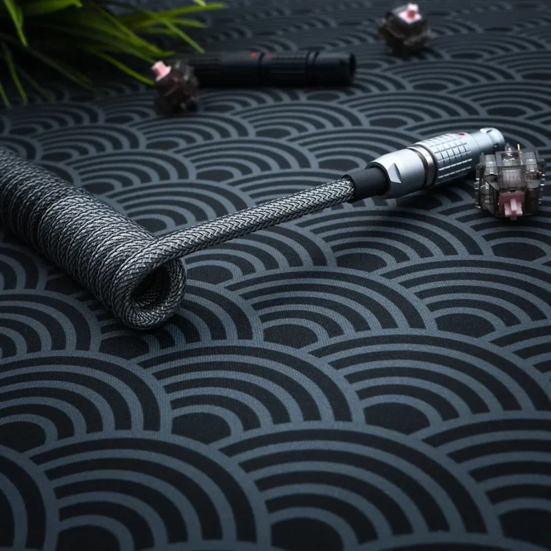 Dark gray coiled cable angled lemo pattern Coiled dark gray keyboard cable featuring a sleek braided design and detachable connectors. The metal housing adds durability, perfect for custom setups.