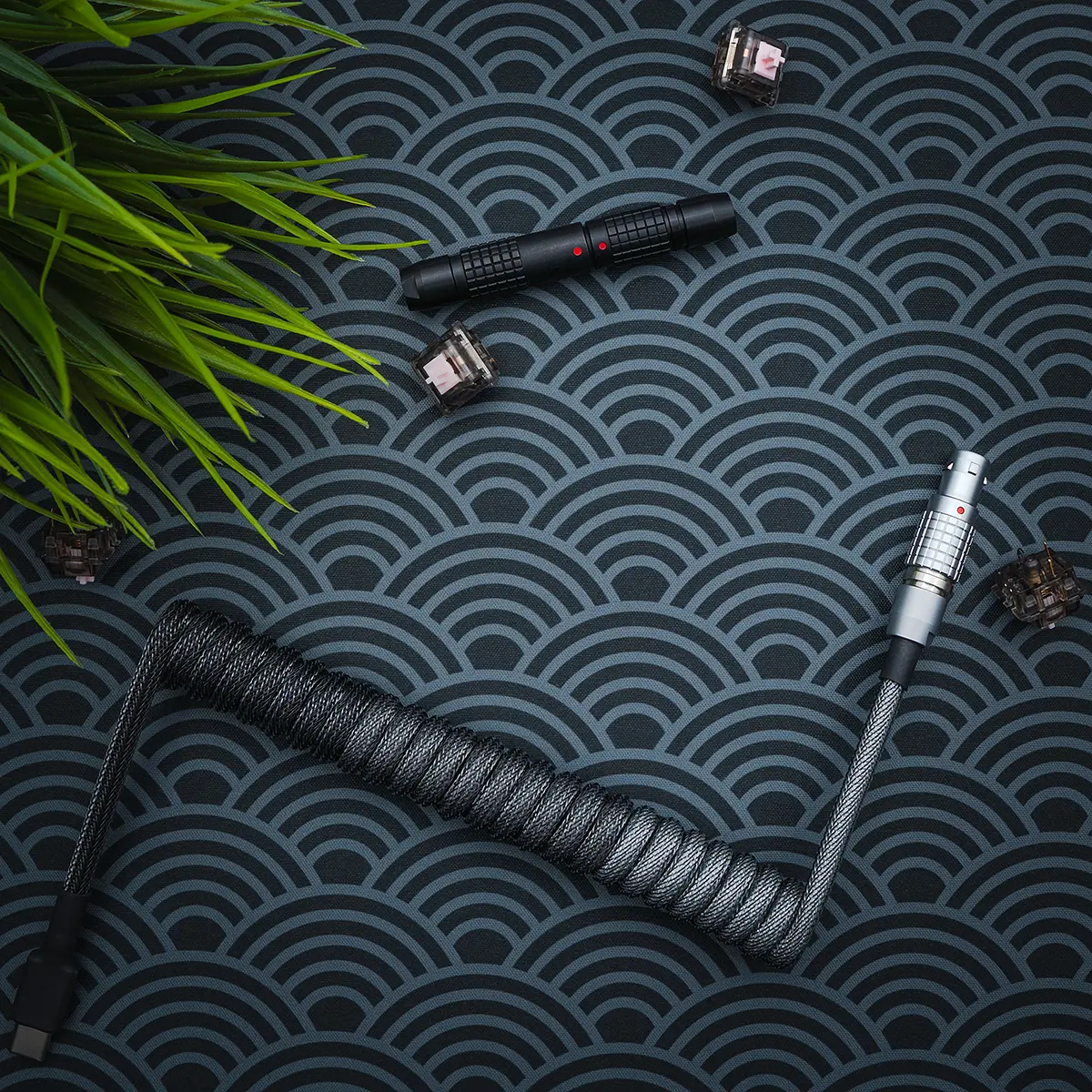 Dunkelgraues Spiralkabel über Kopf lemo wie 1 Dunkelgraues, gewickeltes Tastaturkabel mit einer schlanken, geflochtenen Textur. Verfügt über USB-C-Anschlüsse, einen abnehmbaren AVIATOR-Stecker aus Metall und einen hochwertigen Schrumpfschlauch.