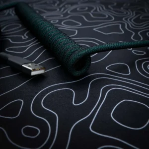 Dark green coiled usb cable angled view A stylish green coiled keyboard cable with a braided finish, featuring a USB connector, ideal for custom setups and high-quality connectivity.