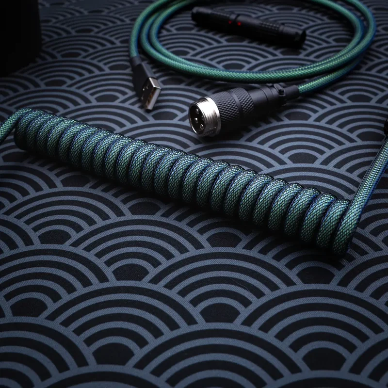 Green coiled cable gx16 connector overhead Coiled green keyboard cable with glow-in-the-dark features, USB and aviator connectors, braided techflex, and high-quality CNC metal housing for durability.