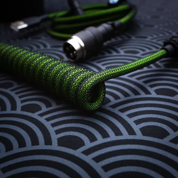 Coiled green keyboard cable with black braided covering, featuring a CNC metal aviator connector and a straight cable portion for versatility.