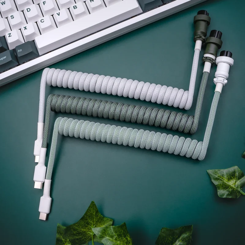 Grün grau Spiralkabel usb c Draufsicht Gewickelte Tastaturkabel aus grauem und grünem Paracord mit USB-C-Anschlüssen, abnehmbaren Steckern und CNC-Metallgehäuse für erstklassige Qualität und Langlebigkeit.