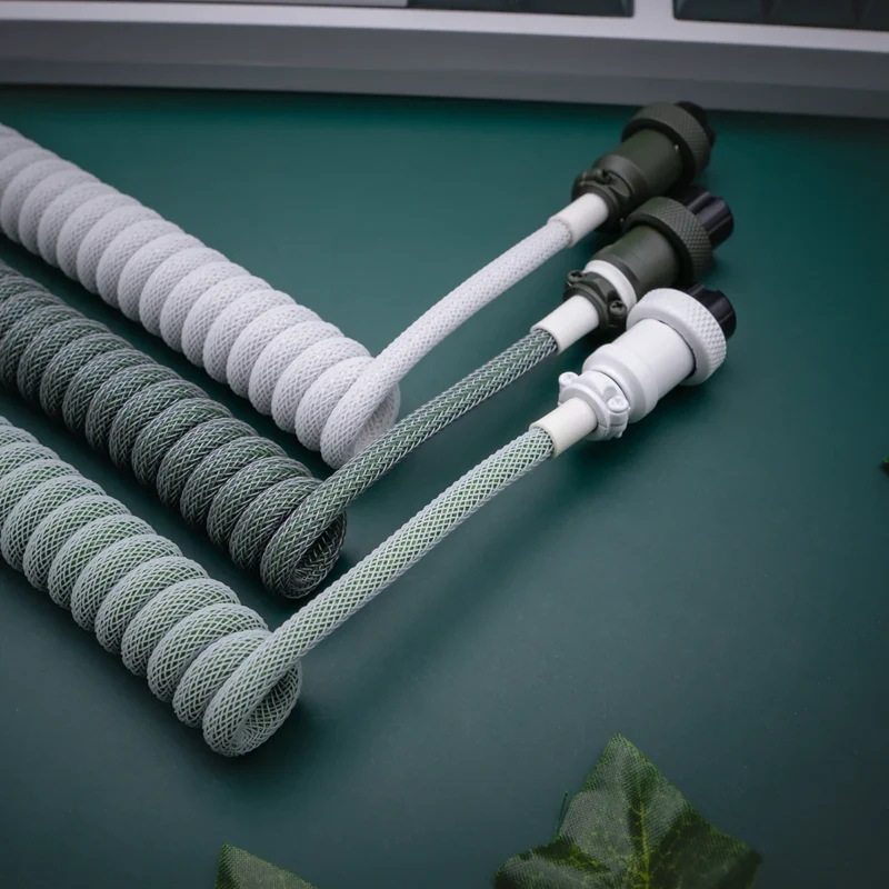 Green white coiled cables angled gx16 connectors Custom keyboard cables in a botanical theme, featuring coiled designs in gray and green, nylon braiding, and detachable connectors for easy use.