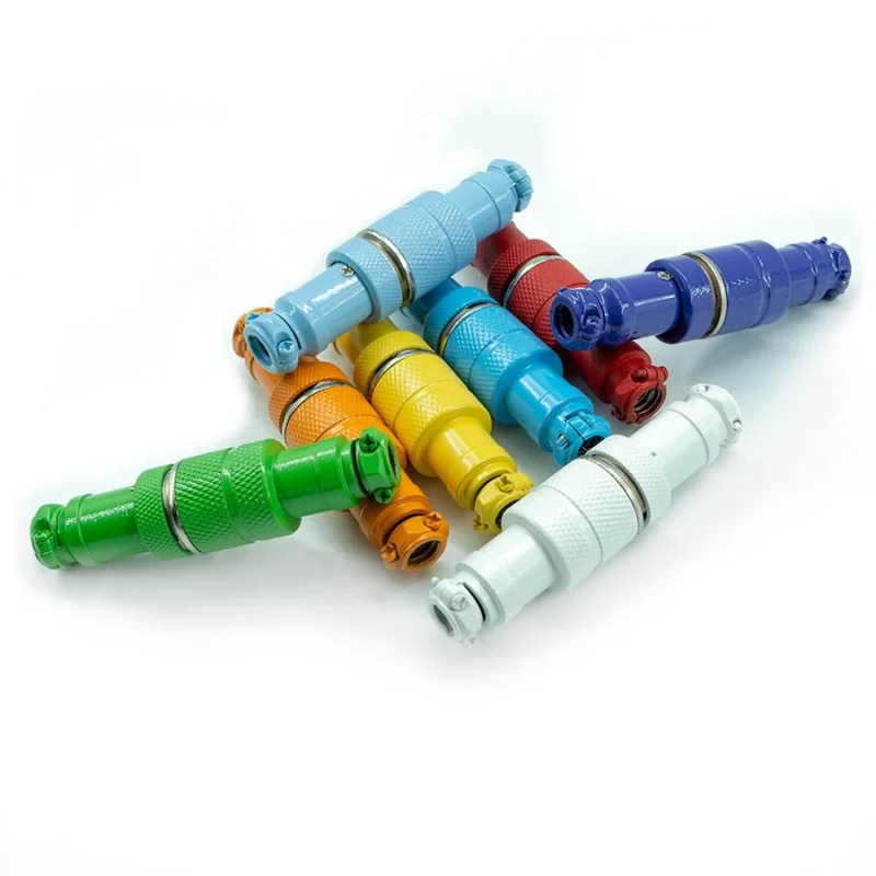Gx16 aviateur 4 broches revêtement poudre Huit connecteurs cylindriques colorés, dont un connecteur aviation GX16 à 4 broches, sont disposés sur un fond blanc. Chaque connecteur revêtu de poudre présente une couleur différente : vert, orange, jaune, bleu, rouge et blanc.