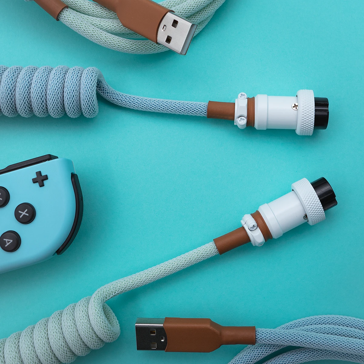 Hellblaues Spiralkabel USB Aviator Overhead Das gewickelte PBT Islander-Tastaturkabel verfügt über ein hellblaues und braunes Paracord-Design, USB-C- und Pilotenanschlüsse mit einem robusten CNC-Metallgehäuse, das sich perfekt für benutzerdefinierte Setups eignet.