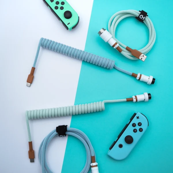 Mint blue coiled usb c overhead view Curled light blue PBT Islander keyboard cable features USB-C and aviatior connectors, sleek paracord design, and quality heatshrink for durability.