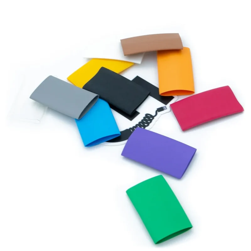 Multiple 3 1 heatshrink 1 2 colors Ten colorful 3:1 Heatshrink - 1/2 rectangular silicone sleeves are arranged in a loose circle cables hero logo around on a white background.