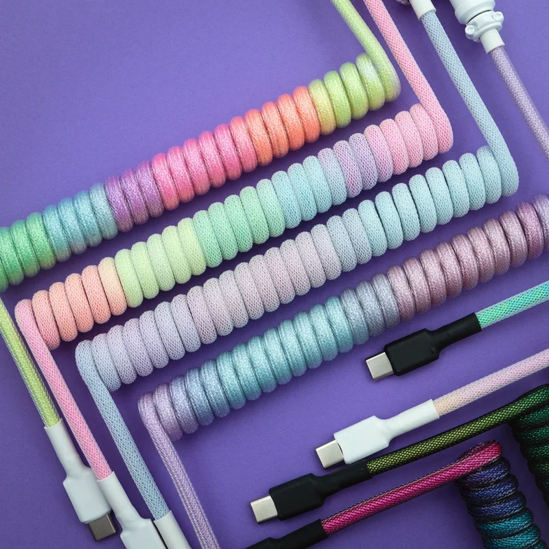 Pastel rainbow coiled cables usb c top view Colorful custom keyboard cables feature various coils and textures, including USB-C connectors and detachable plugs, showcasing vibrant, braided designs.