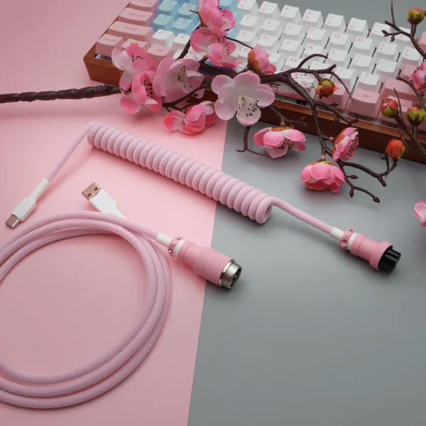 Coiled pink paracord keyboard cable with USB-C and aviator connectors, featuring quality braiding, detachable plugs, and stylish heatshrink details.
