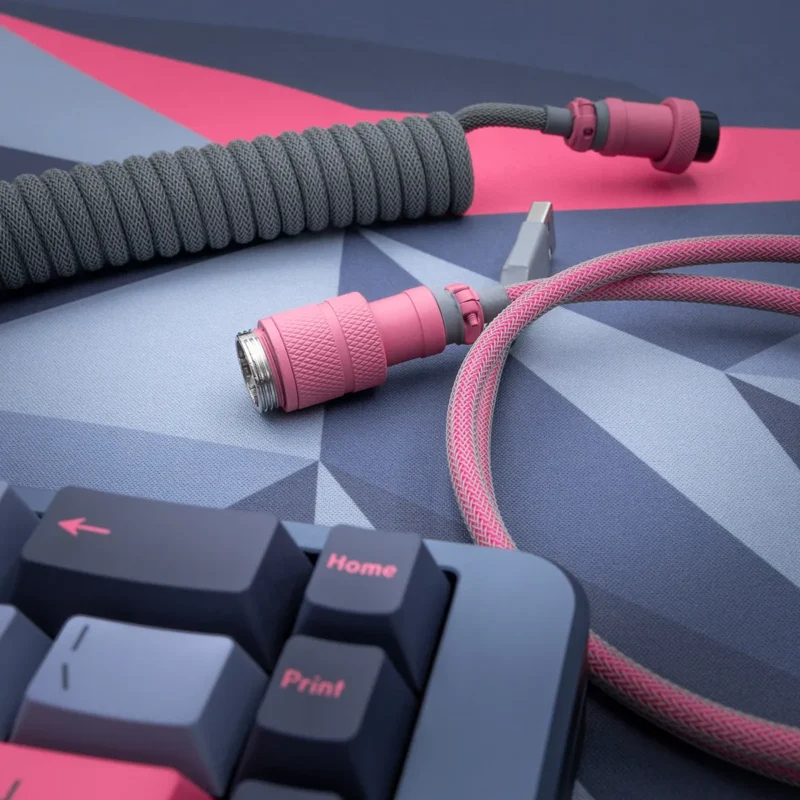 Pink gray coiled cable angled gx16 connector Custom keyboard cable featuring a coiled gray paracord with pink accents, detachable aviator plugs, and quality braiding for durability.
