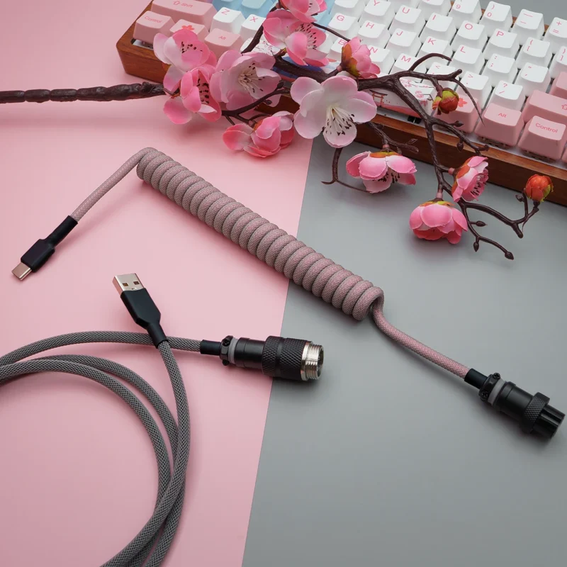 Pink gray coiled cable overhead gx16 connector Coiled pink paracord keyboard cable with USB-C and aviator connectors. Features quality braiding and detachable plugs for flexibility and style.