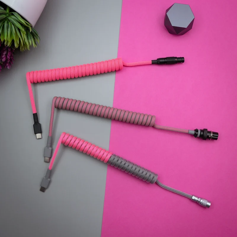 Rosagraue Spiralkabel für den Overhead-Piloten Drei speziell angefertigte Tastaturkabel zeigen leuchtend rosa und graue Paracord-Geflechte. Zu den Anschlüssen gehören USB-C- und Pilotenoptionen, die von hochwertiger Verarbeitung zeugen.