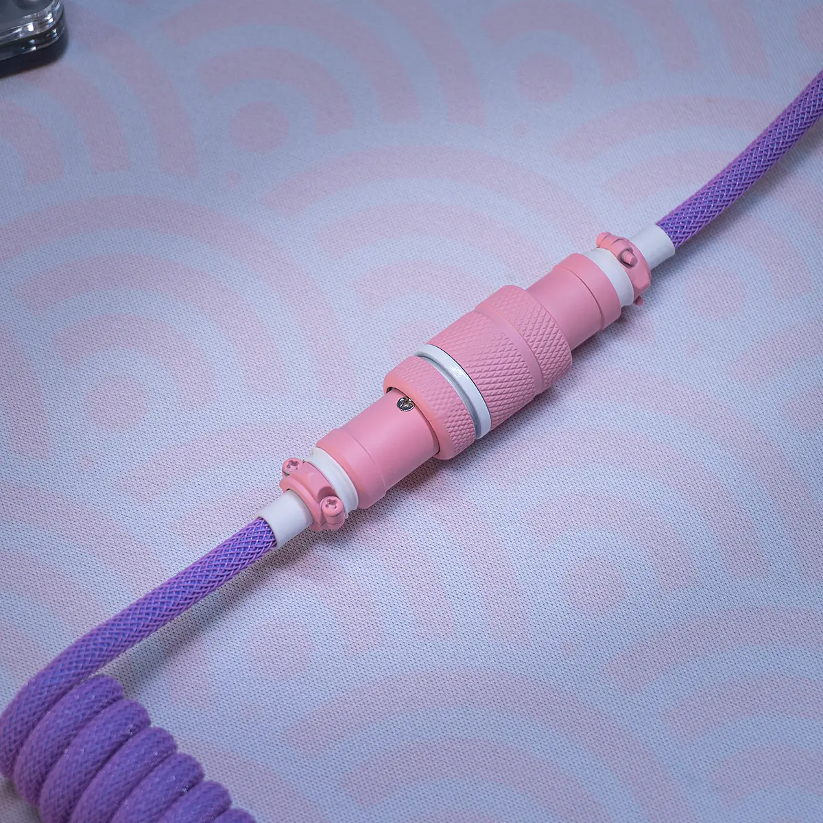 Pink purple cable aviator connector closeup Coiled keyboard cable featuring a vibrant purple paracord design, detachable USB-C connector, and a stylish pink CNC metal housing with textured finish.