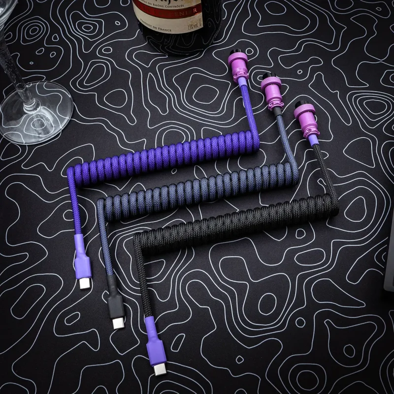 Lila schwarz Spiralkabel USB C Draufsicht 1 Spiralförmige Custom-Tastaturkabel in Lila und Schwarz, mit USB-C-Anschlüssen, abnehmbaren Steckern, einem Techflex-Finish und hochwertigem Geflecht.