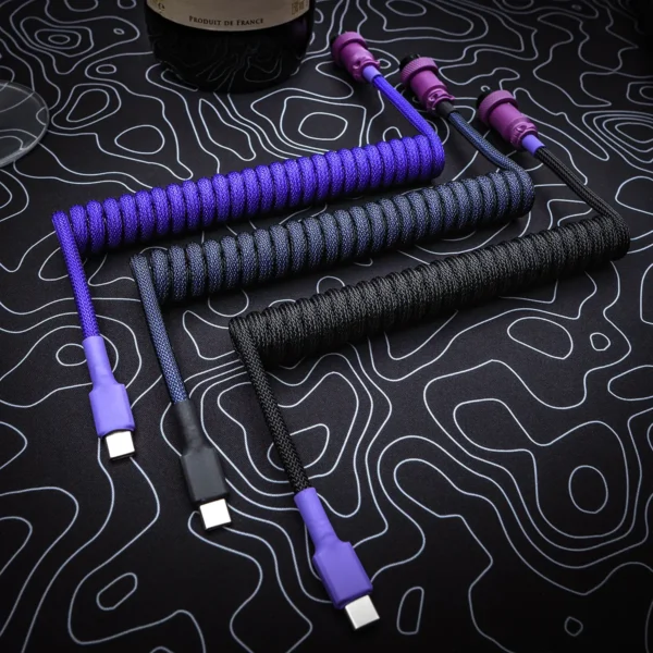 Purple black coiled cables usb c top view Custom keyboard cables featuring coils in purple and black paracord, USB-C connectors, and sleek detachable plugs, designed for style and durability.