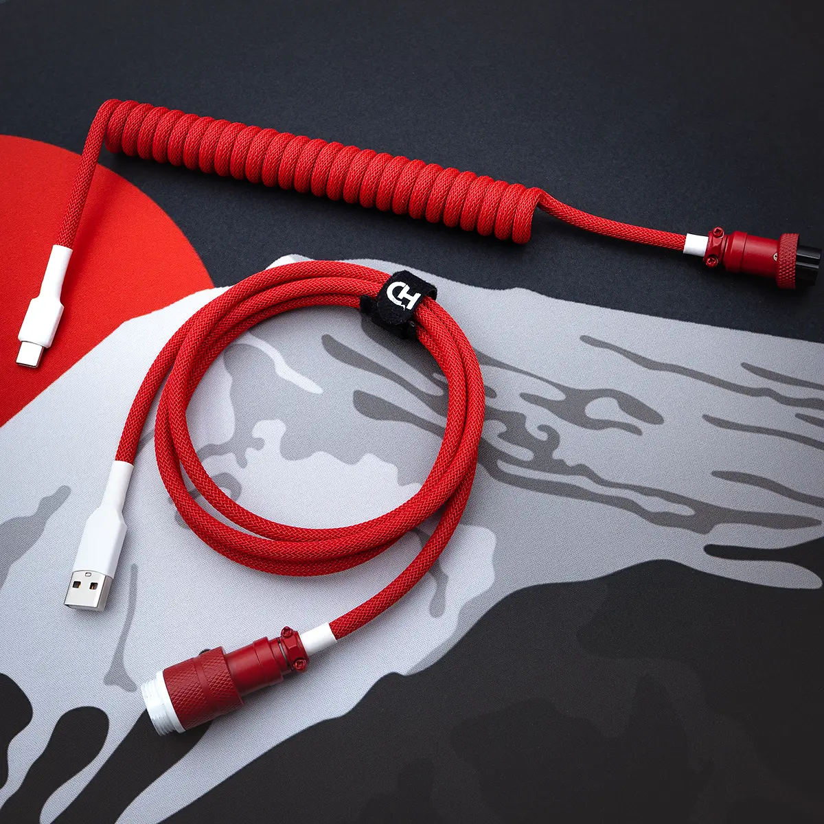 Red coiled keyboard cable overhead aviator A vibrant red GMK Jamon cable features a coiled design with a USB-C connector and a detachable aviator plug