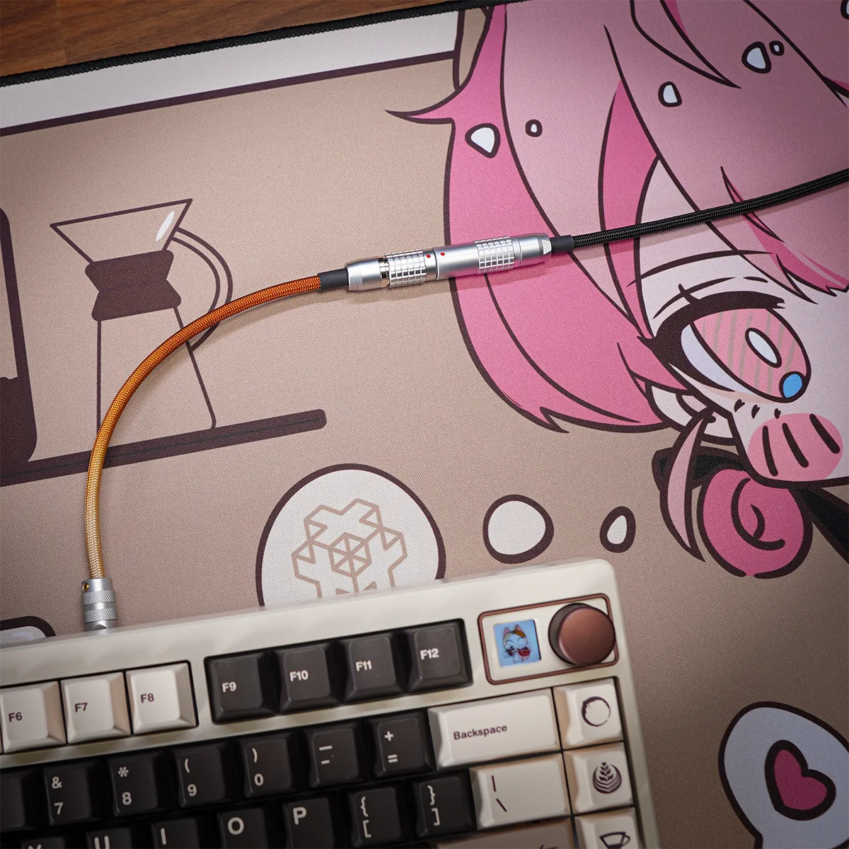 Straight keyboard cable nekoccino theme A mechanical keyboard with dark and light keys sits on an illustrated desk mat featuring a pink-haired anime character; it’s connected by the Straight keyboard cable nekoccino theme, which lies across the mat.
