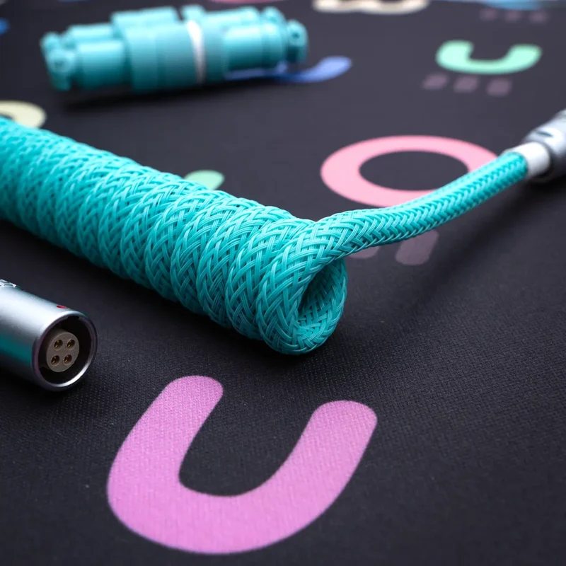 Turquoise coiled cable gx16 closeup shot Coiled turquoise keyboard cable with sleek braided finish, featuring detachable connectors and high-quality metal housing for durability and style.