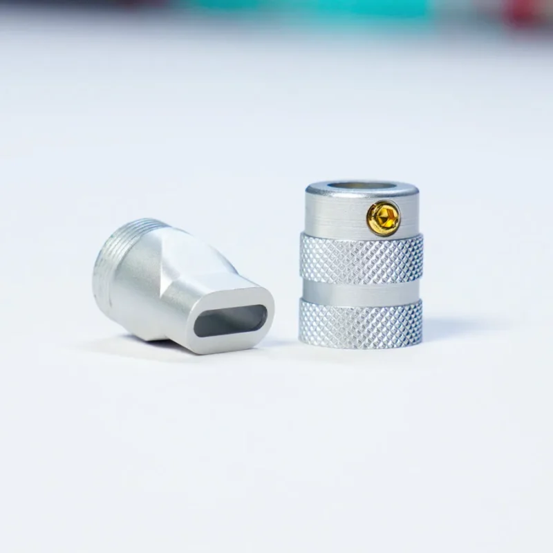 Usb type c connector aluminum silver Two silver metal fittings with knurled grip, one is upright with a visible screw, the other lies on its side showing a rectangular opening. Precision-made for USB Type C - Housing CNC applications.