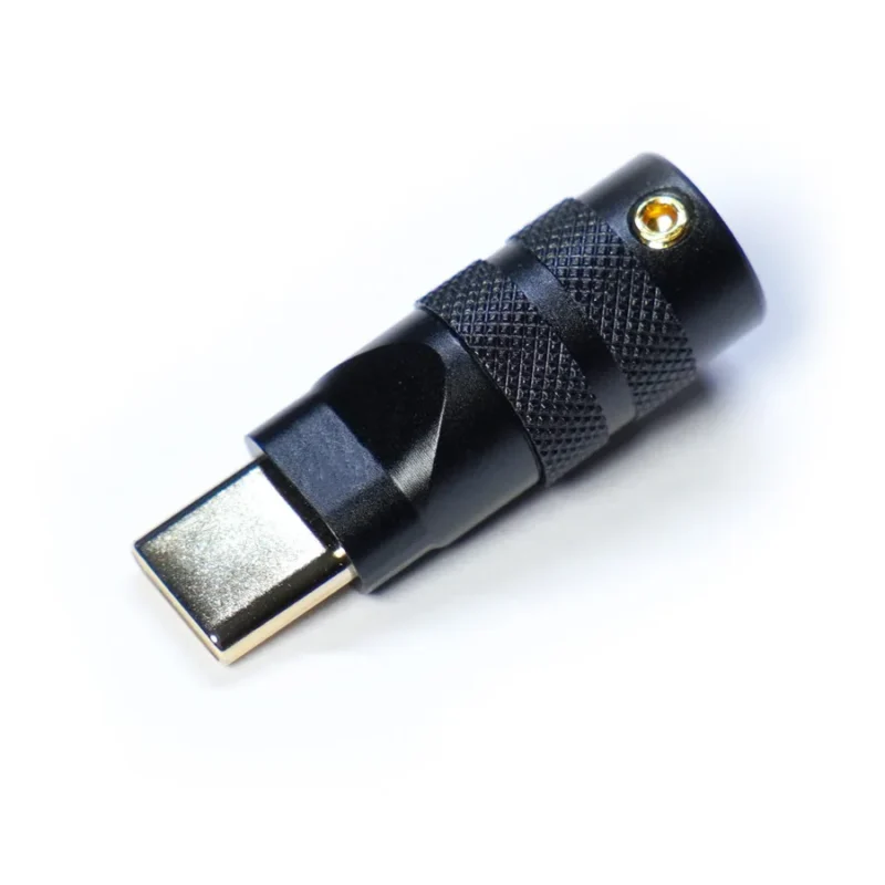 Usb typec connector housing cnc black A close-up of a metallic USB Type C featuring black Housing CNC precision, with a textured grip and a gold-plated connector, photographed on a light background.