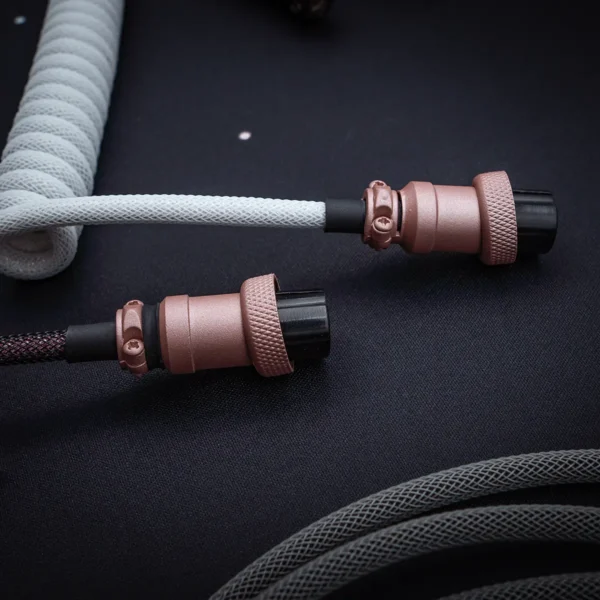 Coiled GMK Olivia keyboard cable features a sleek paracord finish, dual detachable plugs (USB-C and aviator), and premium CNC metal housing for durability.