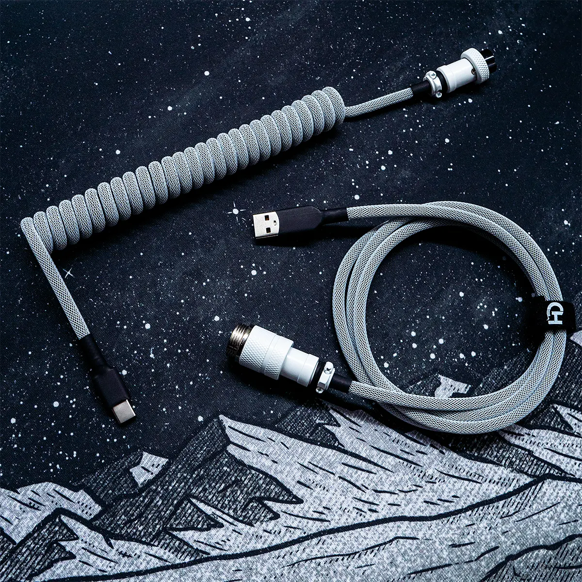 Weiß auf schwarzem Spiralkabel über USB C GX16 Anschluss Ein gewickeltes GMK Classic BoW-Tastaturkabel mit grauem Paracord, abnehmbarem USB-C-Anschluss und CNC-Pilotengehäuse aus Metall für erstklassige Qualität und Stil.