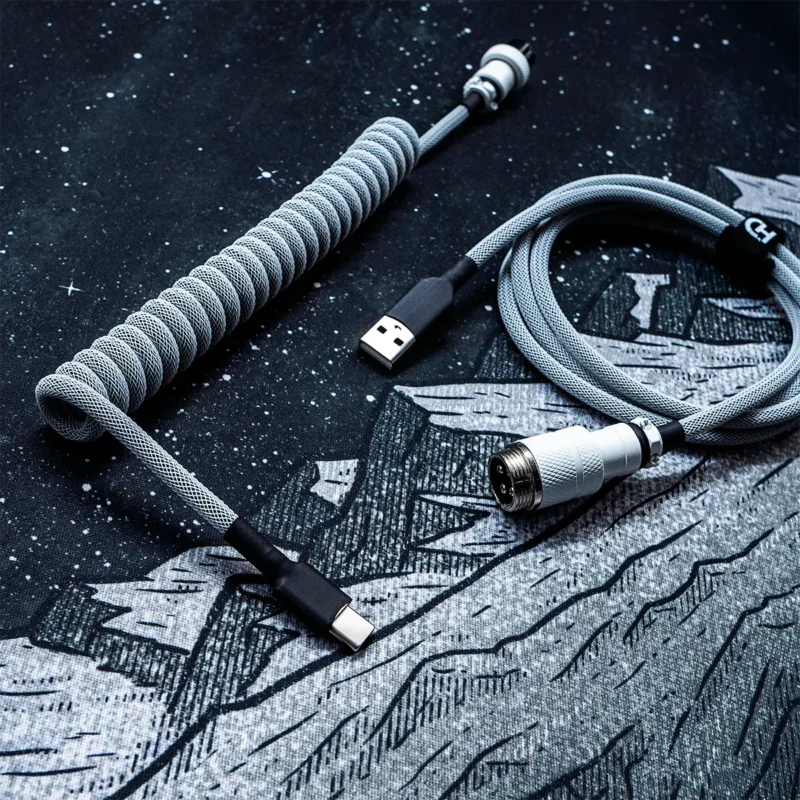 White on black coiled cable usb c gx16 top view Coiled white and black keyboard cable with USB-C and gx16 aviator white connector. Features durable techflex braiding