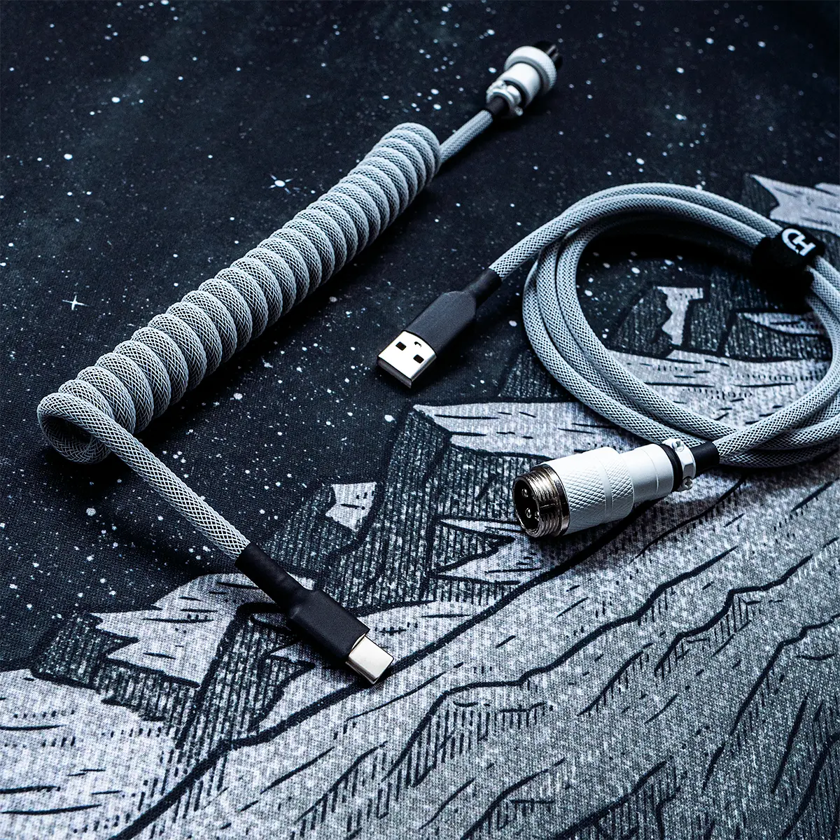 Weiß auf schwarzem Spiralkabel USB C GX16 Draufsicht Graues Tastaturkabel mit Spirale und USB-C- und Pilotensteckern. Verfügt über ein strapazierfähiges Techflex-Geflecht