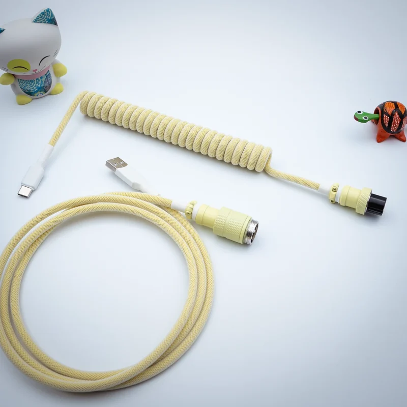 Yellow coiled cable usb c gx16 top view Coiled yellow keyboard cable featuring USB-C and detachable connectors. Includes a straight cord section